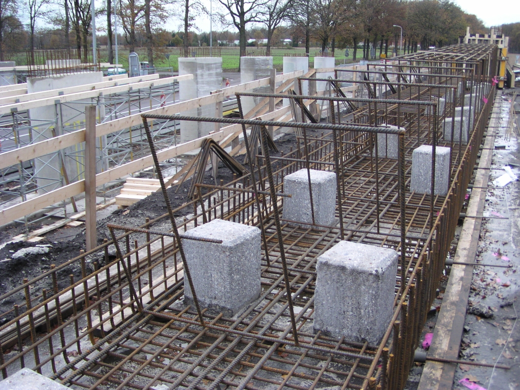 pb100012.jpg - Vlechtwerk viaduct Oirschotsedijk. Kennelijk is het opruwen van de heipalen voldoende voor de hechting van het brughoofd beton want er zijn geen tekenen dat men de heipalen nog gaat openbreken om de wapening van de palen te vervlechten.