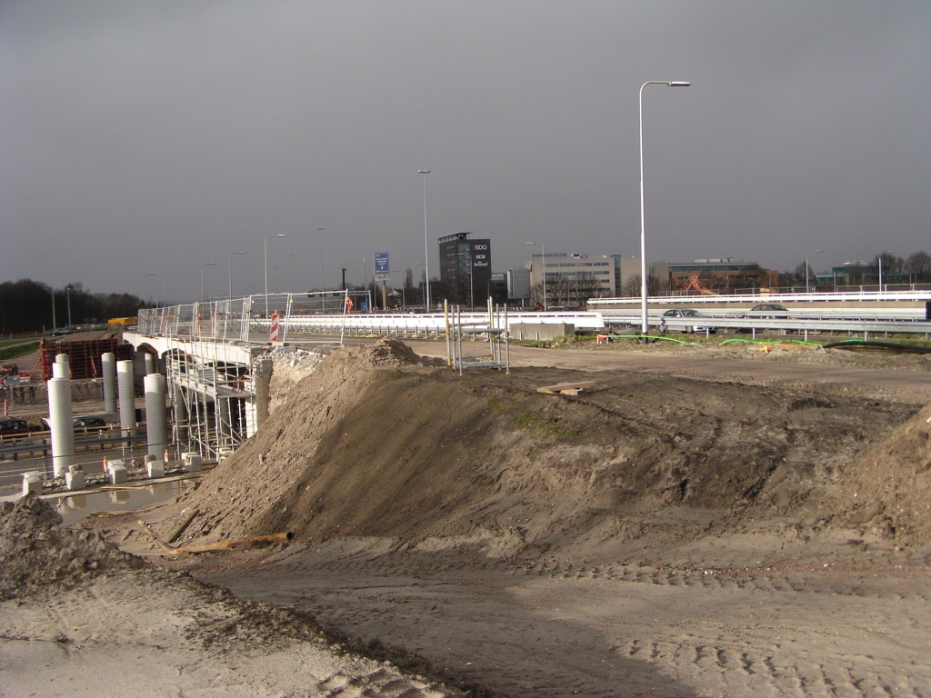 p3240006.jpg - Westzijde KW 13 (aansluiting Veldhoven) waar, in tegenstelling tot aan de oostzijde, nog geen bekisting op de nieuwe palen is aangebracht voor de verbreding van de bestaande toe/afrit viaducten tot parallelbaan. Een ander verschil is dat er hier maar twee pilaren in de breedte zijn bijgezet, terwijl dat er aan de andere kant drie zijn.