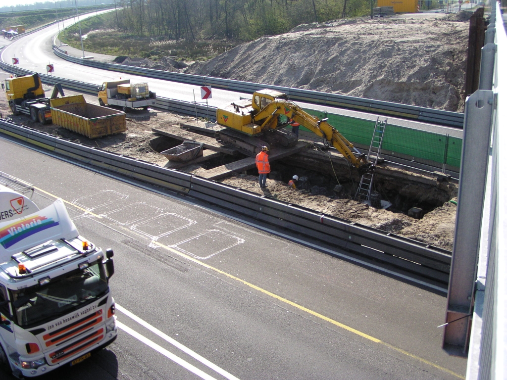 p4170043.jpg - Vanaf het hulpviaduct in de O.L. Vrouwedijk over de A67 zien we dat de oude heipalen, die bij het  uitrijden van KW H  werden begraven, het daglicht weer mogen zien.
