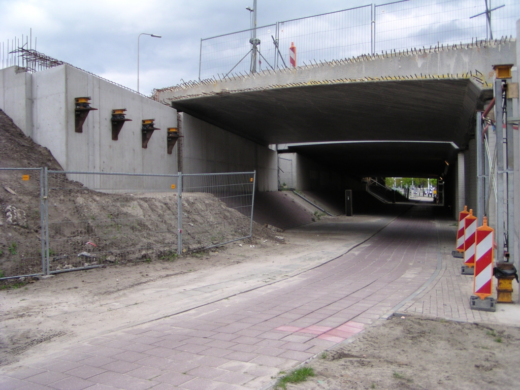 p4300035.jpg - Met ongetwijfeld forse investeringen werd ergens in de jaren negentig veel moeite getroost om de nieuwe viaducten in de aansluiting Veldhoven zoveel mogelijk in jaren zestig stijl op te richten. De verkeerskundige leek snapt het nut van deze gescheiden viaducten voor in/uitvoeg doeleinden nog minder als bij de Beatrixbruggen. De boogstralen werden in dit geval alleen maar krapper. De verbreding uit de vorige foto leek afdoende. Wat was er gaande in de jaren negentig? De startnotitie van het huidig project was in 1994, was er toen niet al bekend dat de toekomst parallelbanen zou brengen? De kapitaalvernietiging is overigens kleiner dan bij de Beatrixbruggen, waar twee viaducten gesloopt werden. Hier kan worden volstaan met verbreding van de in/uitvoeg viaducten tot parallelbaan breedte.
