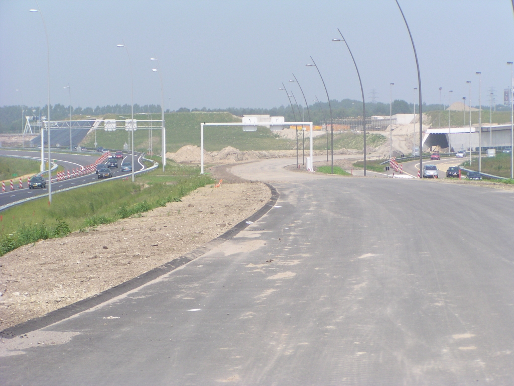 p6080008.jpg - Verder verloop van de parallelbaan vanaf KW 5 naar KW 6 (fotostandpunt), die inmiddels is geasfalteerd. Het parallelbaan west wegvak tussen kp. Batadorp en de aansluiting Airport zou deze maand moeten opengaan. Er zijn hier geen oversteekjes in aanbouw te zien met de oude hoofdrijbaan, zodat het erop lijkt dat het verkeer dan onder KW 5 door gaat rijden.  week 200819 