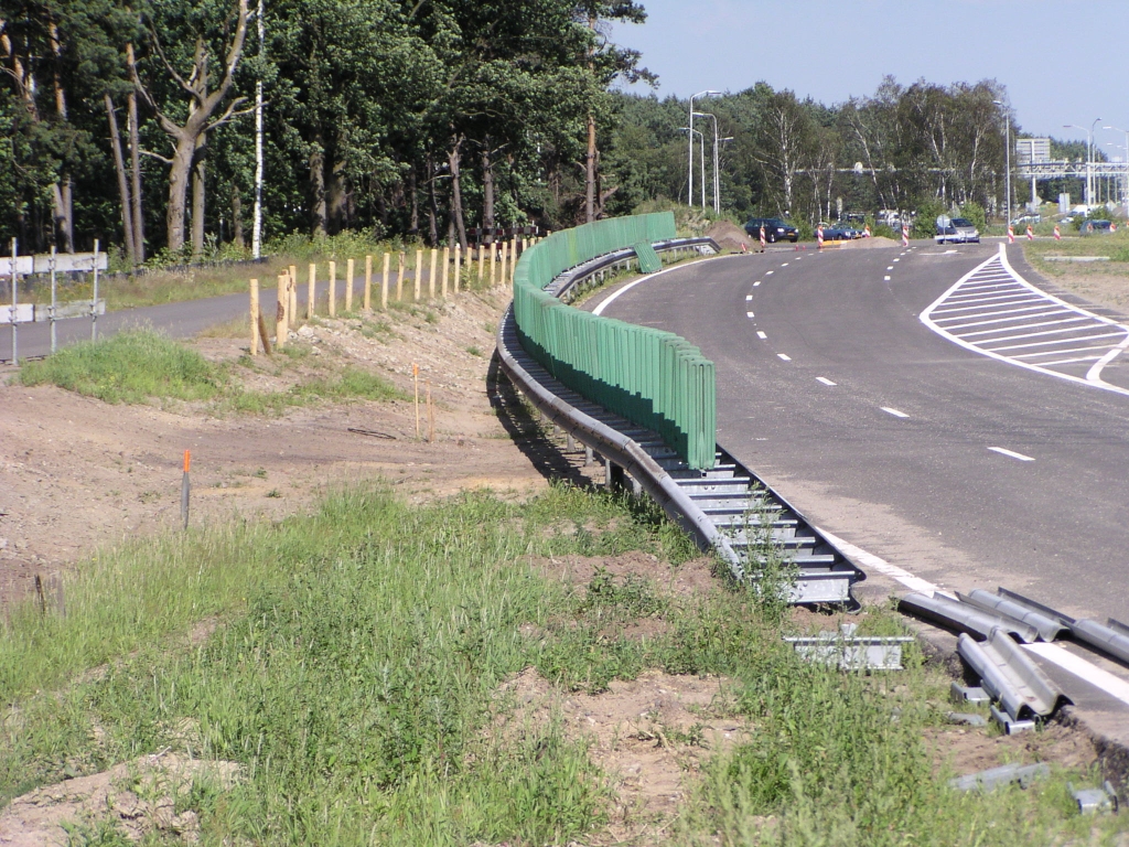 p6270047.jpg - Ter afscheiding van het vervaarlijk dicht bij de tijdelijke parallelbaan nabij kp. Leenderheide gelegen fietspad zijn een aantal maatregelen getroffen zoals houten paaltjes met ijzerdraad ertussen, geleiderails en antiverblindings opzetstukken. Als de parallelbaan op zijn definitieve plek ligt, verder naar rechts, komt er een bermsloot.
