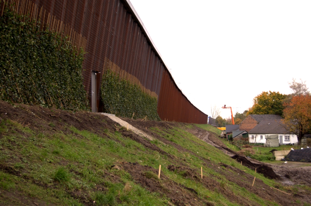 20081102-165853.jpg - Het traliewerk is over de gehele hoogte van het scherm aangebracht. De planten zouden dus uiteindelijk het gehele scherm aan het oog kunnen onttrekken. De piketpaaltjes wekken de indruk dat er ook op het talud nog wat aangeplant gaat worden.