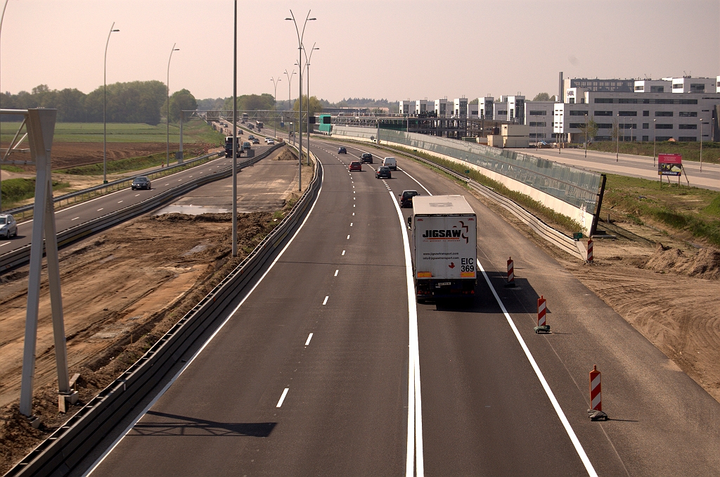 20090418-135925.jpg - Resultaat van de reconstructie van de noordelijke A67 rijbaan locatie Veldhoven vier weken geleden, die we om 1 of andere reden nog niet eerder op de plaat hadden gezet. Het is niet de definitieve situatie, omdat de DZOAB deklaag nog ontbreekt en er geen thermoplast is toegepast in de markering. Ook de lange doorgetrokken streep in de invoeger van de verbindingsweg Amsterdam-Antwerpen is geen blijvertje. De blokmarkering begint in de eindsituatie al ruim voor het viaduct waarvan de foto genomen is.  week 200912 