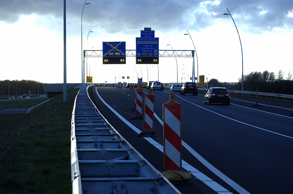 20091122-163256.bmp - Als we het goed begrepen hebben krijgen we per 2 december 2009 een fasering waarbij de A2 hoofdrijbaan tussen de knooppunten Ekkersweijer (foto) en Batadorp wordt opengesteld en het verkeer daar weer terugslingert naar de parallelrijbaan. De rijbaan waar al het verkeer thans overheen rijdt in de foto zou dan alleen dienen als verbindingsweg in de richting Breda. Op het rechterbord moeten de bijgeruiterde doelen dan worden verwijderd en verder alles afgekruisd behalve "Tilburg". Van het linker bord kunnen de magneten verwijderd, en de lokale doelen bijgeruiterd  zoals in kp. Leenderheide is gedaan .  week 200911 