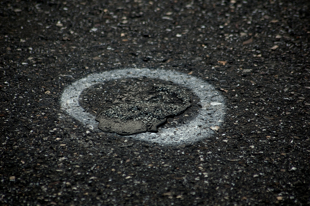 20110519-191104.jpg - Meerdere van deze wit omlijnde "blazen" op het viaduct. Hier is het asfalt plaatselijk omhooggekomen, maar werd al eerder provisorisch hersteld. In het huidige garantiewerk verdwijnen deze wonden dus met de complete vervanging van het asfalt.
