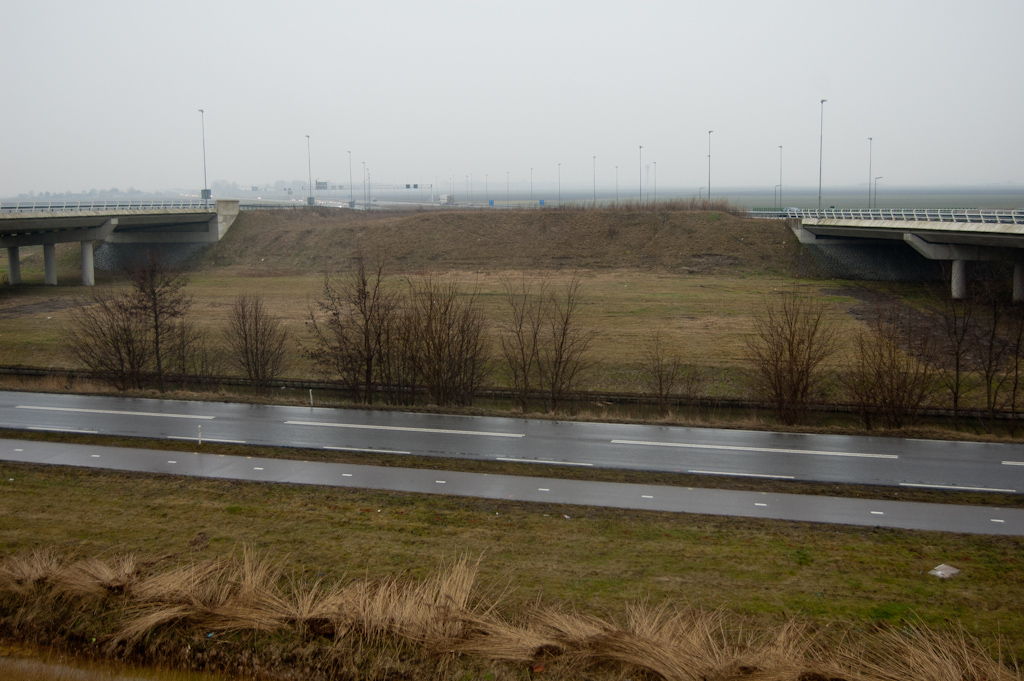 20100123-163227.jpg - Er is dan ook een hoop lege ruimte in het knooppunt Raasdorp. Aan de verhoging in het grondlichaam aan de overzijde van de Schipholweg kun je ongeveer zien waar de doorgaande A5 hoofdrijbanen moeten komen te liggen.  Daarvoor zijn uiteraard ook nieuwe viaducten noodzakelijk. Het valt op dat de bestaande viaducten behalve de Schipholweg en de Spaarnwoudertocht ook een groot stuk weiland overspannen.