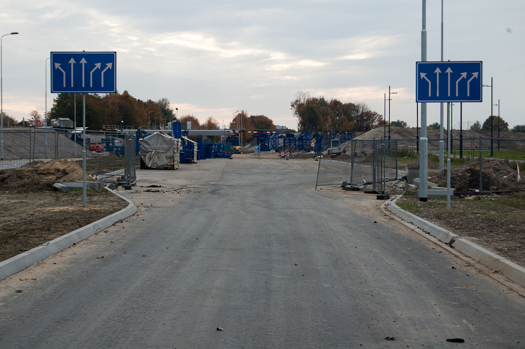 20111030-150844.jpg - In de noordelijke rijbaan van de Noord-Brabantlaan ontbreekt de toplaag nog. Dat zal te maken hebben met de werken die nog bezig zijn aan weerszijden, bij de bouwhekken.