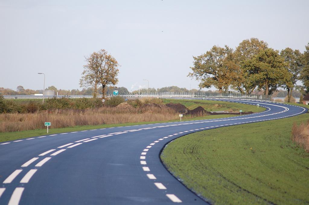 20081016-164118.jpg - Het talud naar de brug over het Dommerskanaal is een beetje een schizofreen geval. De helling is flauw genoeg voor een comfortable rit met 80 en misschien wel 100 km/uur, maar de forse slingers gooien roet in het eten. Vanuit een esthetisch standpunt oogt het meanderende asfaltlint fraai in het landschap, maar wordt ernstig ontsierd door de veel te drukke DV markering.