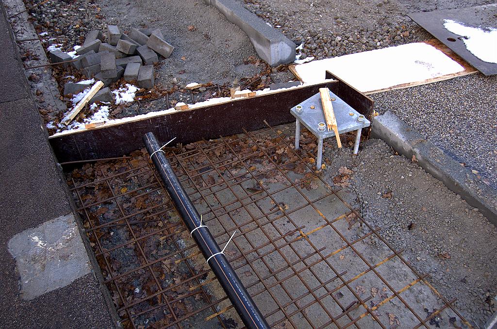 20081122-135703.jpg - Complexe situatie met de stoepverbreding in het viaduct Elburglaan. Er is een bekistingsbakje gemaakt, maar ook boven in de foto steekt nog wapening uit de oude stoep, zodat daar ook nog extra beton in het verschiet ligt. Ertussenin moet dan ook nog de nieuwe voegovergang worden geperst. Bovendien moeten de kabelpijp en de stoepranden netjes over de voegovergang worden geleid.